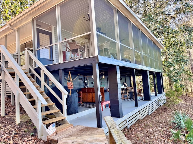 view of home's exterior featuring a wooden deck and a sunroom