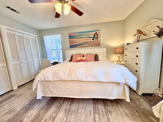 bedroom featuring a closet, ceiling fan, hardwood / wood-style floors, and a textured ceiling