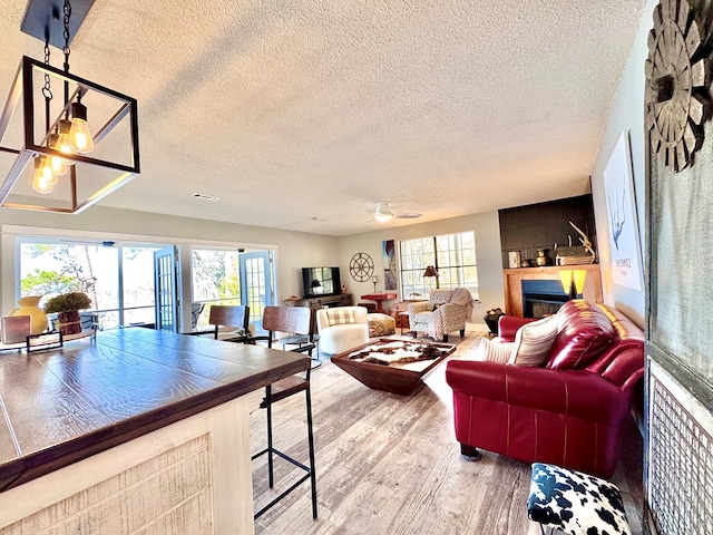 living room featuring hardwood / wood-style floors, a textured ceiling, and a notable chandelier