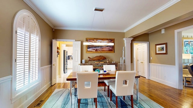 1389 Lake Front Dr, Cairo, GA 39828 - dining area with wood finished floors, wainscoting, healthy amount of natural light, decorative columns, and crown molding