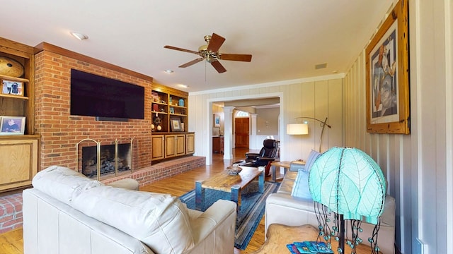 1389 Lake Front Dr, Cairo, GA 39828 - living room featuring wood finished floors, a brick fireplace, built in shelves, ceiling fan, and wood walls