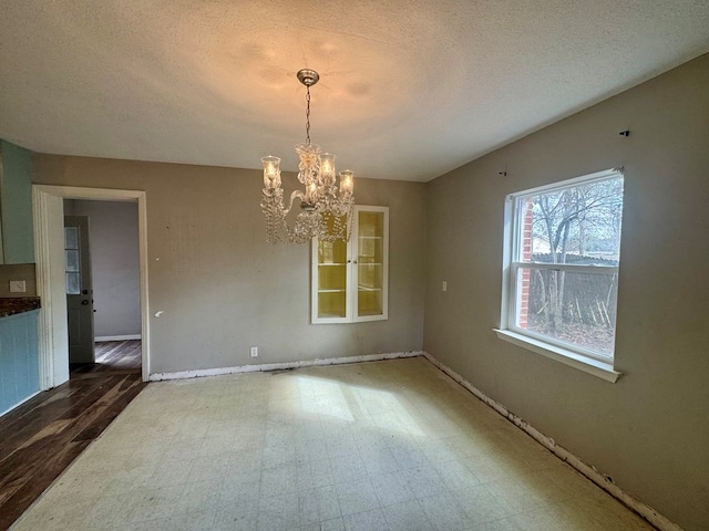 interior space featuring a textured ceiling and a chandelier