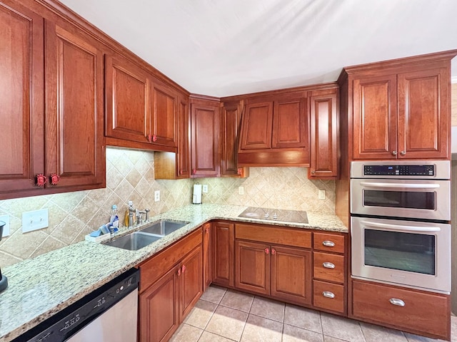 kitchen with sink, stainless steel appliances, light stone countertops, and light tile patterned floors