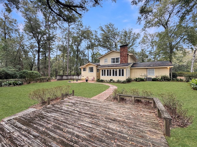 back of house featuring central AC, a lawn, and a wooden deck