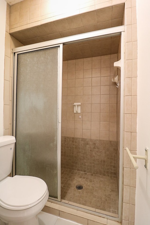 bathroom featuring tile patterned floors, toilet, and walk in shower