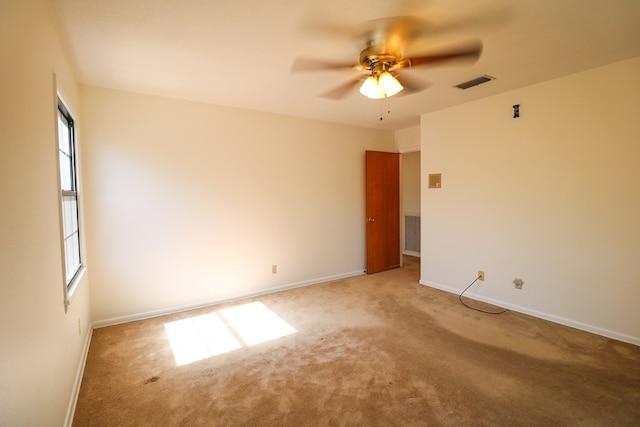 carpeted spare room with ceiling fan