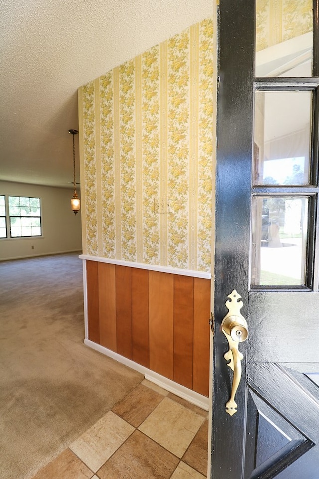 interior space featuring a textured ceiling and wooden walls