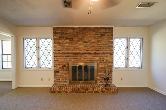 unfurnished living room featuring carpet flooring, a fireplace, a textured ceiling, and ornamental molding