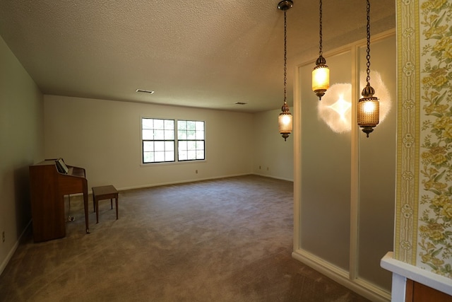 carpeted empty room with a textured ceiling