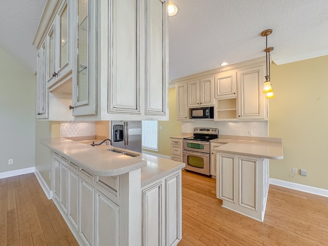 115 Lakeside Ln, Bainbridge, GA 39819 - kitchen featuring double oven range, black microwave, a peninsula, light countertops, and a textured ceiling