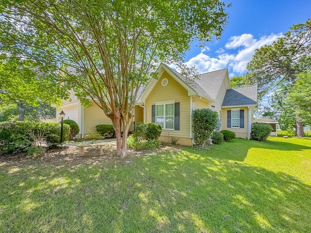 115 Lakeside Ln, Bainbridge, GA 39819 - view of property hidden behind natural elements featuring a front yard, roof with shingles, and an attached garage