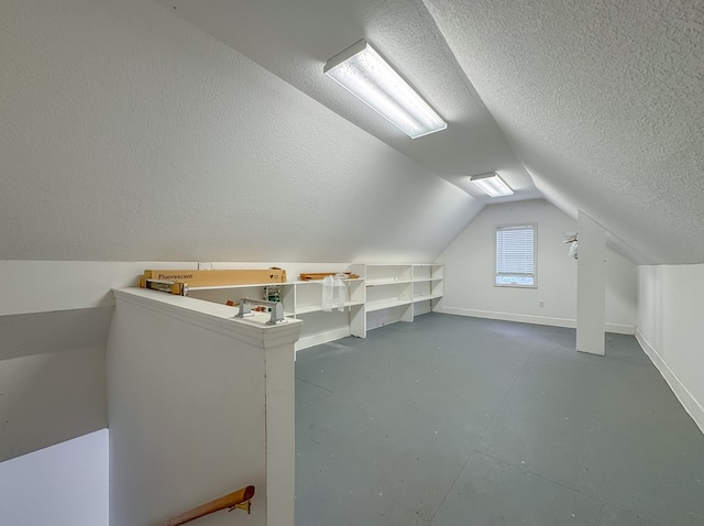 115 Lakeside Ln, Bainbridge, GA 39819 - bonus room with a textured ceiling, baseboards, vaulted ceiling, and concrete floors