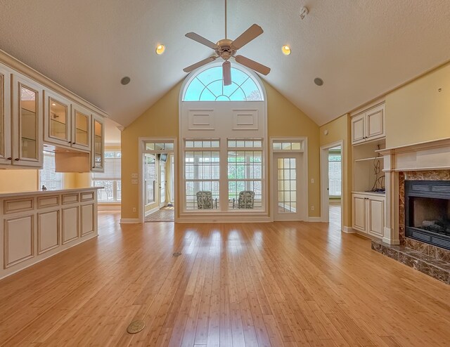 115 Lakeside Ln, Bainbridge, GA 39819 - unfurnished living room with a fireplace, a ceiling fan, light wood-style flooring, baseboards, and high vaulted ceiling