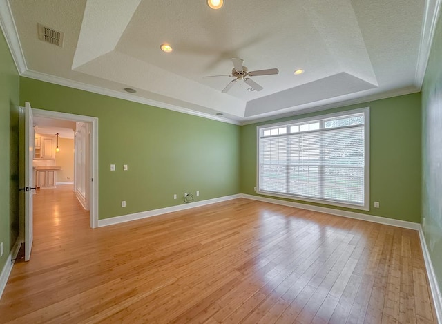 115 Lakeside Ln, Bainbridge, GA 39819 - empty room featuring a tray ceiling, ceiling fan, light wood finished floors, baseboards, and crown molding