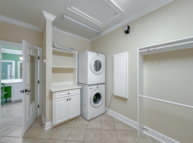 115 Lakeside Ln, Bainbridge, GA 39819 - laundry area featuring estacked washer and dryer, crown molding, light tile patterned floors, baseboards, and cabinet space