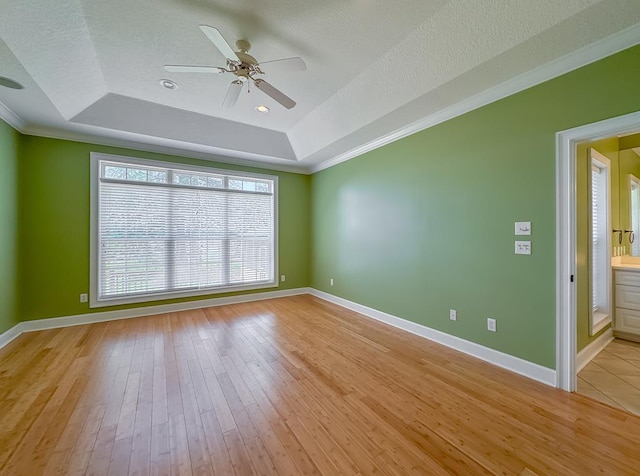 115 Lakeside Ln, Bainbridge, GA 39819 - spare room with a tray ceiling, crown molding, a ceiling fan, light wood-style floors, and baseboards