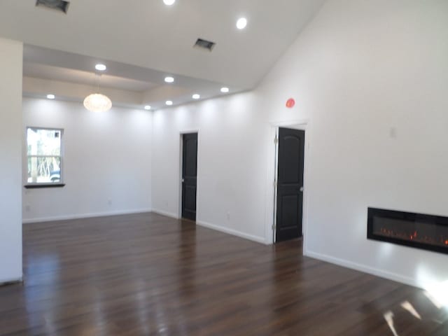 unfurnished room with dark wood-type flooring and vaulted ceiling