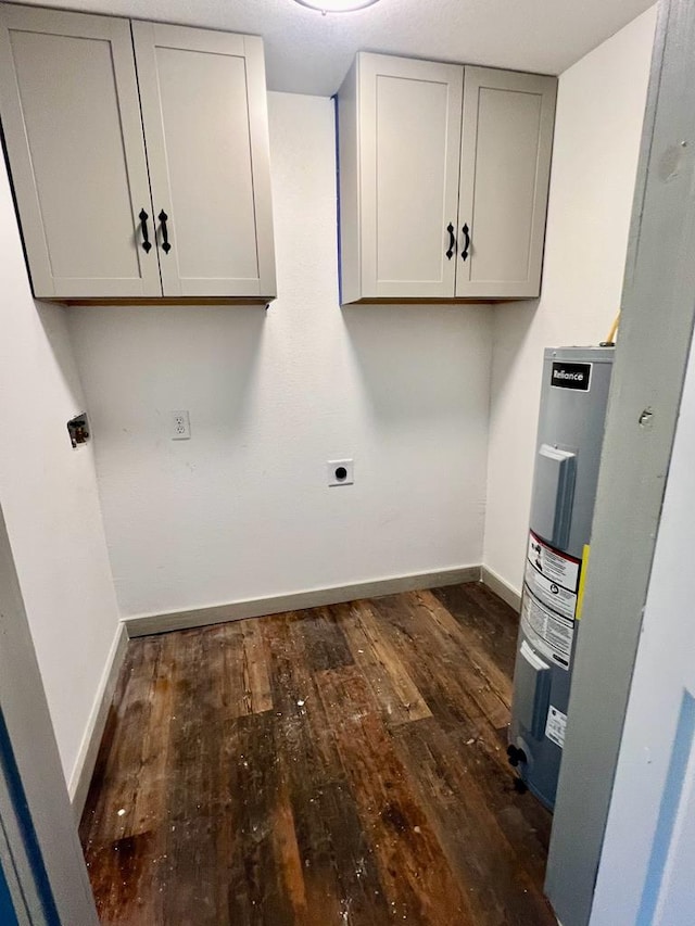 clothes washing area with electric dryer hookup, electric water heater, dark hardwood / wood-style flooring, and cabinets