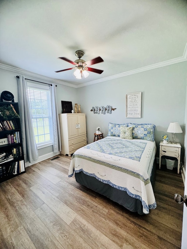 bedroom with ceiling fan, ornamental molding, and light wood-type flooring