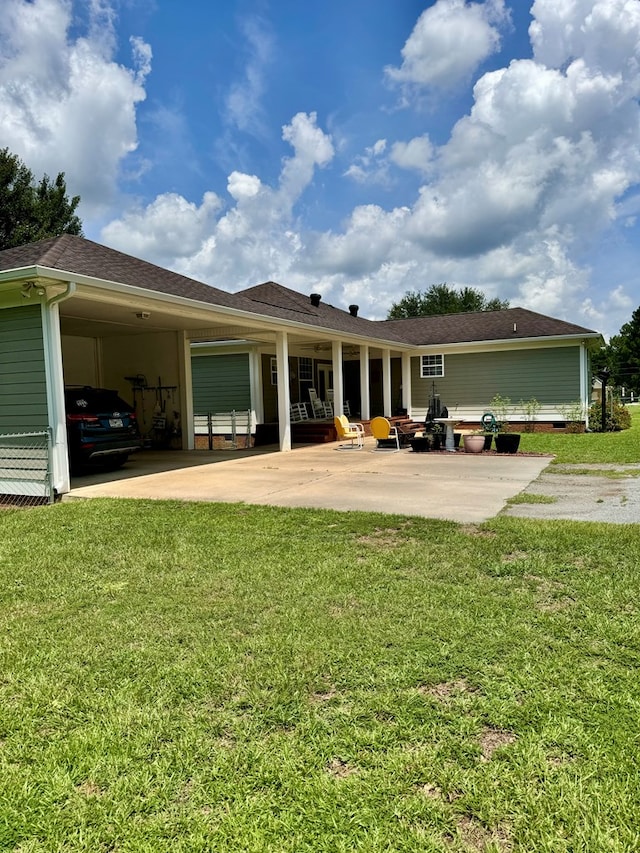 back of property with a yard and a carport