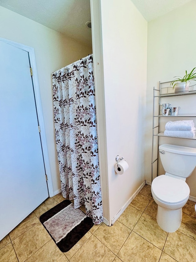 bathroom featuring walk in shower, tile patterned flooring, a textured ceiling, and toilet