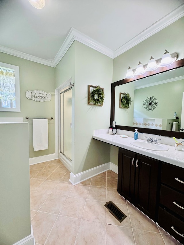 bathroom featuring tile patterned flooring, vanity, a shower with door, and ornamental molding