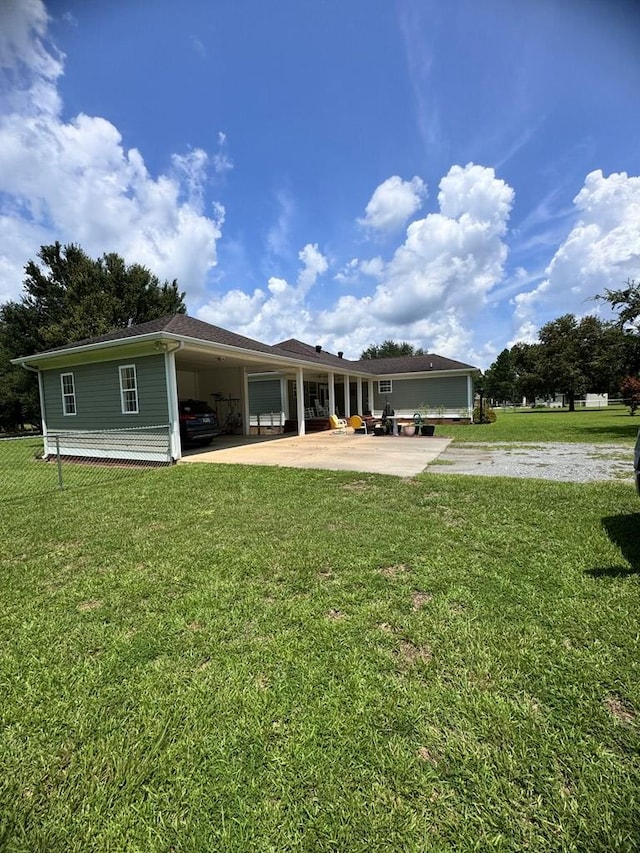 rear view of property featuring a carport and a yard