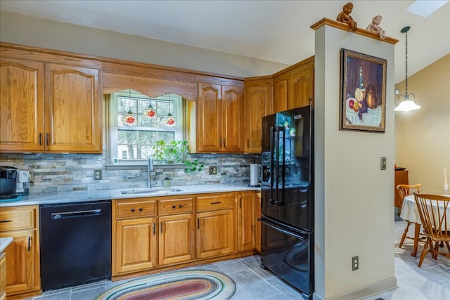 kitchen with brown cabinetry, a sink, black appliances, and tasteful backsplash