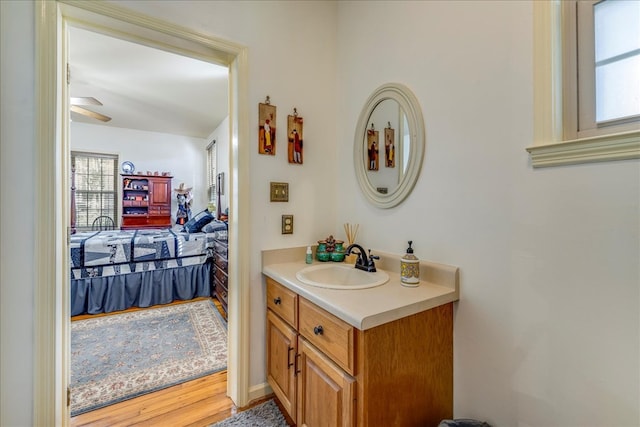 bathroom with ceiling fan, vanity, and wood finished floors