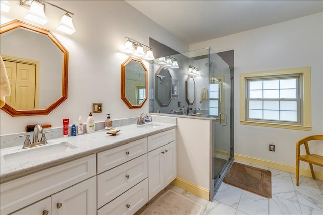 full bathroom with double vanity, marble finish floor, a sink, and a stall shower