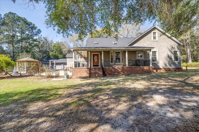 view of front facade featuring a porch, a front yard, and stucco siding