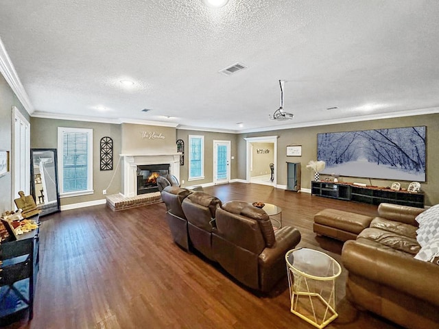 living room featuring a fireplace, crown molding, hardwood / wood-style floors, and a textured ceiling