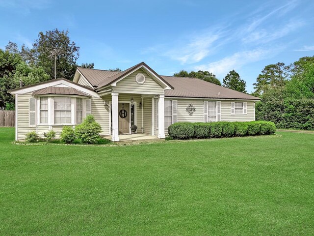 ranch-style home with a front yard and metal roof