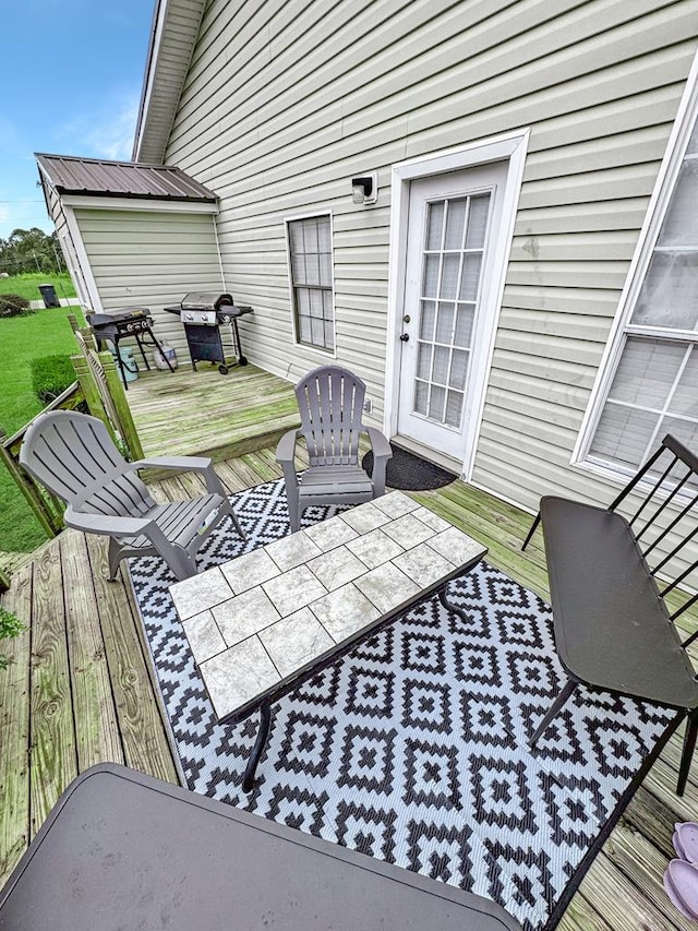 wooden deck featuring outdoor dining space and a grill
