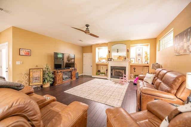 living room featuring ceiling fan, dark wood-type flooring, and a wealth of natural light