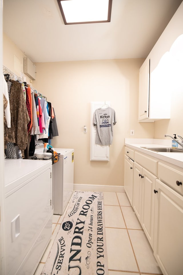 washroom featuring washing machine and dryer, sink, light tile patterned flooring, and cabinets