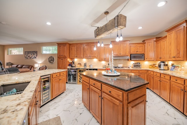 kitchen with appliances with stainless steel finishes, a center island, wine cooler, and pendant lighting