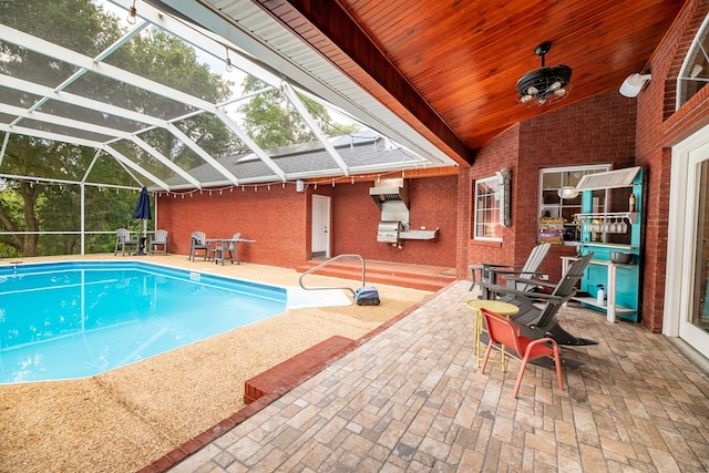 view of pool with a patio and glass enclosure