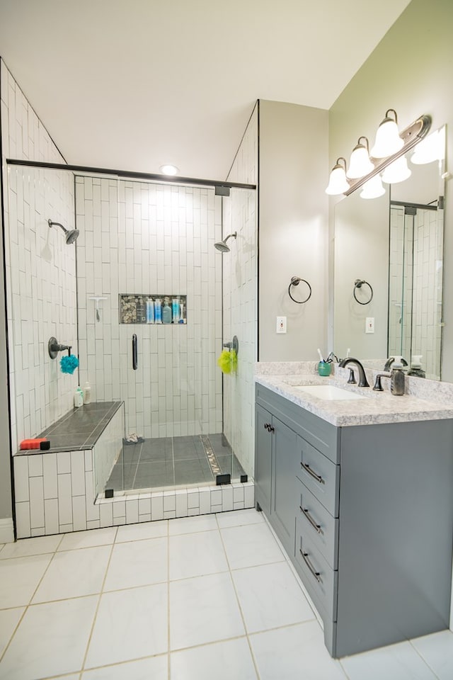 bathroom featuring tile patterned floors, vanity, and a tile shower