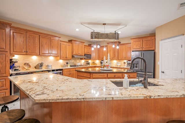 168 Douglas Pointe Dr, Bainbridge, GA 39819 - kitchen with stainless steel appliances, light stone counters, and a breakfast bar