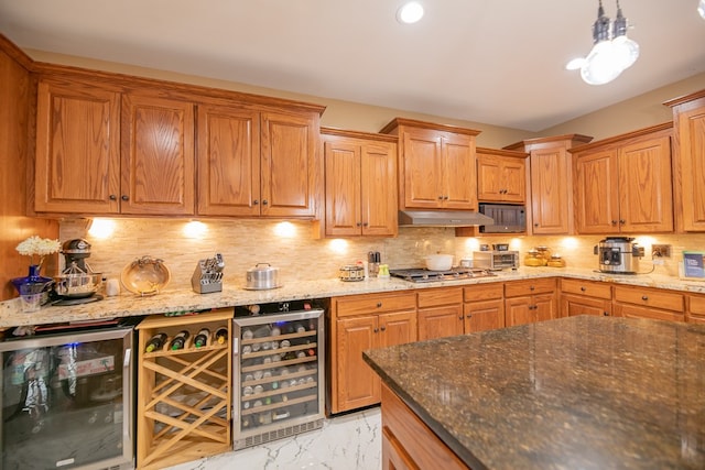 kitchen featuring pendant lighting, backsplash, beverage cooler, and appliances with stainless steel finishes