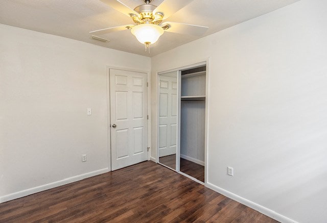 unfurnished bedroom with ceiling fan, dark hardwood / wood-style floors, and a closet