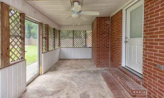 unfurnished sunroom featuring ceiling fan and wooden ceiling