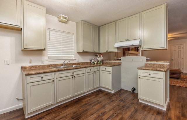 kitchen featuring white cabinetry, sink, dark hardwood / wood-style flooring, stone countertops, and a textured ceiling