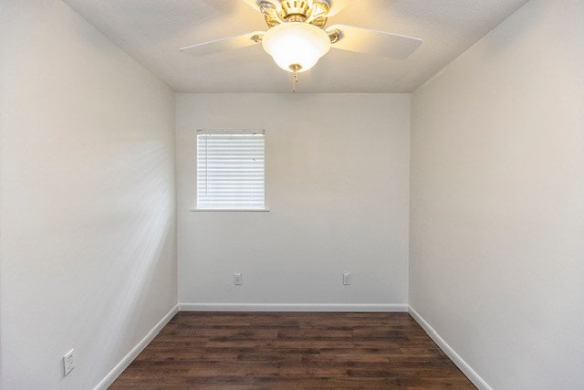 spare room with ceiling fan and dark wood-type flooring