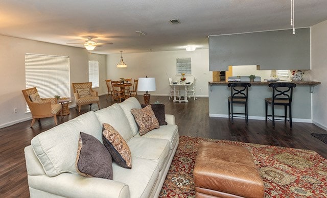 living room with dark hardwood / wood-style floors and ceiling fan