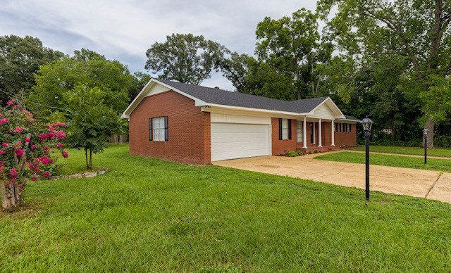 401 Simms St, Bainbridge, GA 39819 - single story home with an attached garage, brick siding, a front yard, and driveway