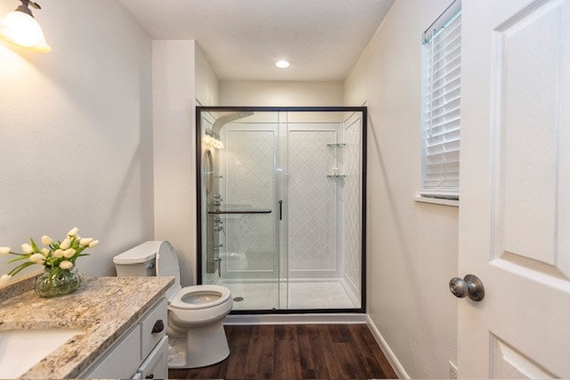 bathroom with toilet, vanity, an enclosed shower, and hardwood / wood-style flooring