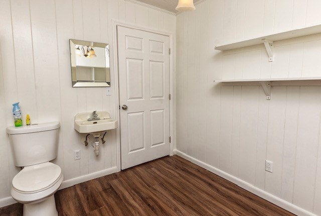 bathroom with wood-type flooring, toilet, ornamental molding, and sink