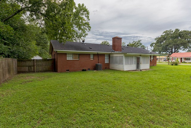 back of house featuring a yard and central AC